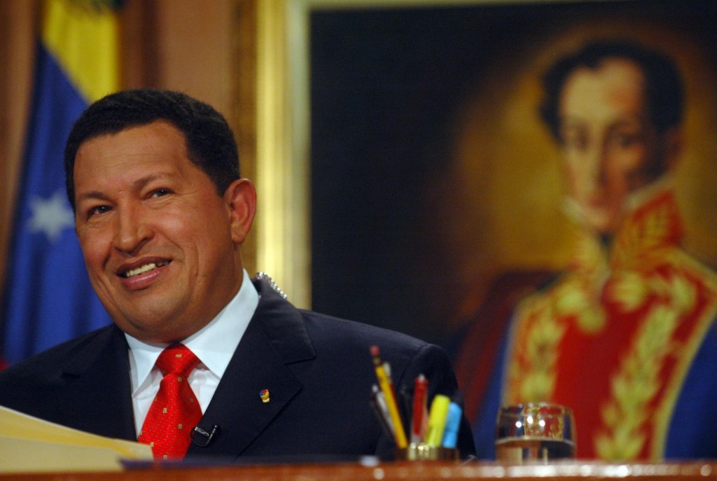 Hugo Chavez delivers an address. Behind him is a portrait of Simon Bolivar.